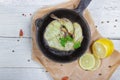 Oven-cooked Wild Black Cod steak Served with Broccoli, parsley and lemon. Light white wooden background, top view