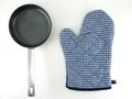 blue white checkered patterned oven glove and empty small teflon frying pan with silver stainless steel handle isolated on white