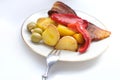 oven grilled bacon slices with delicious curry sauce served on white plate, baked potatoes with meat, red paprika, green capsicum Royalty Free Stock Photo