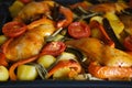 oven grilled chicken legs with delicious curry sauce served on baking tray, baked potatoes with meat, red paprika, green capsicum Royalty Free Stock Photo