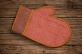 Oven mitt resting on a wooden table showcasing rustic kitchen decor and cooking essentials Royalty Free Stock Photo