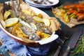 Oven roasted trout and roasted vegetables on a rustic table