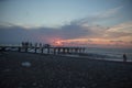 Over Batumi beach Jetty, as powerful waves roll in, and a very colorful sky is reflected on the beach. sunset on the city