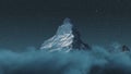 Over clouds to the majestic Matterhorn mountain at night with shooting star