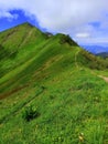 Over the crest, hiking in vertiginous landscape Royalty Free Stock Photo