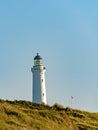 Over the dunes of the Danish North Sea coast towers the lighthouse of Hirtshals