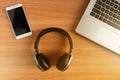 Over-Ear Headphone and smart phone with laptop on wooden floor,used electronics gadgets