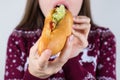 Over eating concept. Cropped closeup photo of crazy hungry girl trying to eat all the sandwich in her hands isolated grey