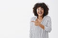 Over-emotive excited and happy cute african american female in striped blouse and glasses laughing from fun and joy