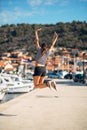 Over exited happy woman jumping in the air out of happiness. Vacation time concept. Seaside coastal vacation excitement. Woman in