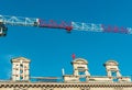 Over head crane, rail and hoist, behind three historic, stone window frames