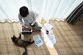 Over head shot of young man working on laptop with his cat on floor. Royalty Free Stock Photo