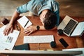 Over it. High angle shot of an exhausted young businessman sleeping at his desk in a modern office. Royalty Free Stock Photo