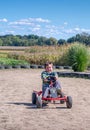 Over joyed child has fun driving a pedal car around a track Royalty Free Stock Photo