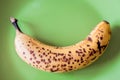 Over riped banana on green plate Royalty Free Stock Photo