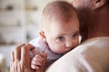 Over shoulder close up of grandfather holding his baby grandson