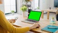 Over the Shoulder: Creative Young Woman Sitting at Her Desk Using Laptop with Mock-up Green Screen Royalty Free Stock Photo