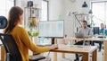 Over the Shoulder: Female Mobile Software Developer Sitting at Her Desk Using Desktop Computer wit