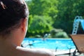 Over the shoulder of unrecognizable mother watching children in pool