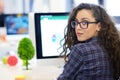 Over the shoulder view of a businesswoman working at computer and pointing to graph