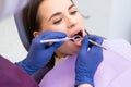 Over the shoulder view of a dentist examining a female patients teeth in dental office Royalty Free Stock Photo