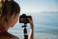 Over the shoulder view of female photographer arranging camera settings Royalty Free Stock Photo