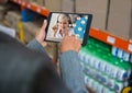 Mixed race woman using a digital tablet for a visio call in a warehouse