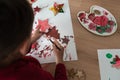 Over the shoulder view of toddler boy making holiday ornaments