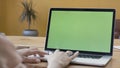 Over the shoulder view of a woman hands using laptop with green screen. Stock footage. Female hands typing on a laptop Royalty Free Stock Photo