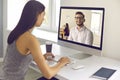 Young woman sitting at computer and having video call with coworker or HR manager