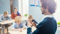 Over the Soulder Shot of Teacher Explaining Lesson to Classroom Full of Diverse Bright Children, I Royalty Free Stock Photo