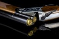 Over and Under Shotgun Loaded with Cartridges on a Reflective Black Surface Royalty Free Stock Photo