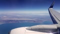 Over-wing view from airplane in blue sky over Greenland Royalty Free Stock Photo