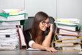 Over-worked woman in office, speaking on phone.