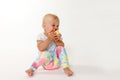 Overall view of sitting cool toddler girl eating red apple Royalty Free Stock Photo