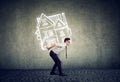 Overburdened business man carrying a house Royalty Free Stock Photo