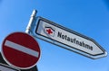 Overburdened healthcare sector concept: Isolated direction sign with red cross for hospital emergency department german word: