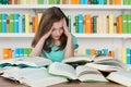 Overburdened Schoolgirl Studying In Library Royalty Free Stock Photo