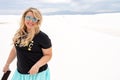 Beautiful blonde woman smiles and poses at White Sands National Monument in New Mexico