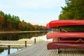 Rack of red canoes on dock of Old Ausable Channel river in the Pinery Provincial Park in the autumn