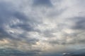 Overcast gray cumulus clouds of various shapes in the white sky. Royalty Free Stock Photo