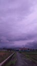 overcast purple sky full of clouds with views of rice fields and mountains