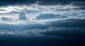 Overcast sky filled with dramatic, layered dark and light blue clouds with hints of sunlight breaking through the Royalty Free Stock Photo