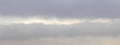 Overcast sky with gray clouds and light stripe in the middle, light blur, sky panorama