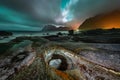 Overcast sky lit by Aurora Borealis over the famous rock formation, Dragon\'s Eye