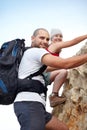 Overcoming obstacles as a couple. Portrait of a young couple climbing a rock face together.