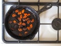 Overcooked onion in a pan. A bad kitchen. The concept of harmful food and carcinogens.