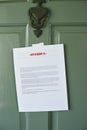 Overdue Notice Posted on a Door of a Home - Letter - Late Payment - Rent - Mortgage - Green Front Door with Knocker