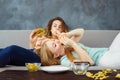 Overeaten women lying at coach eating fast food