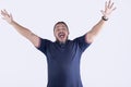 An overexcited man throwing his hands up in elation. Yelling and feeling on cloud nine. Isolated on a white backdrop Royalty Free Stock Photo